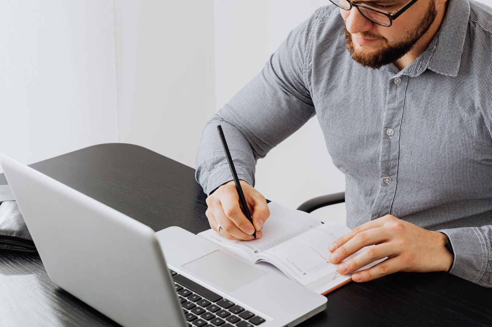Manager planning the week on a laptop and notebook