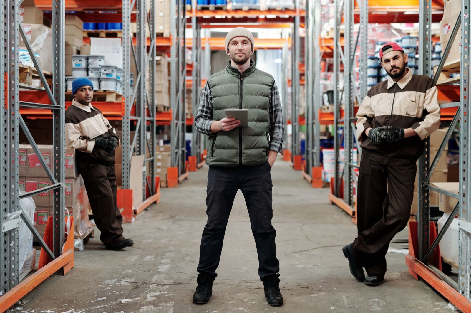 Warehouse team standing between racks of stock
